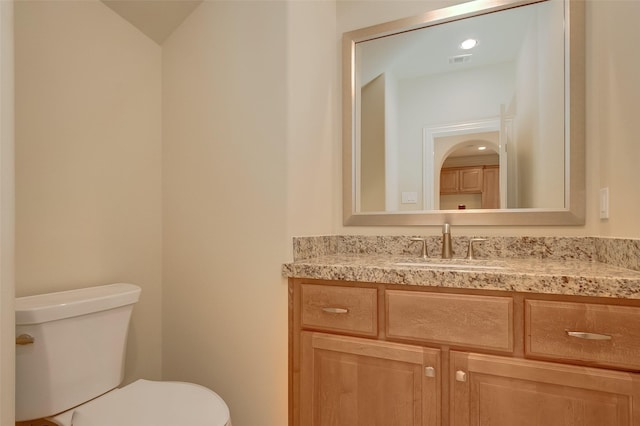 bathroom featuring vanity, toilet, and visible vents