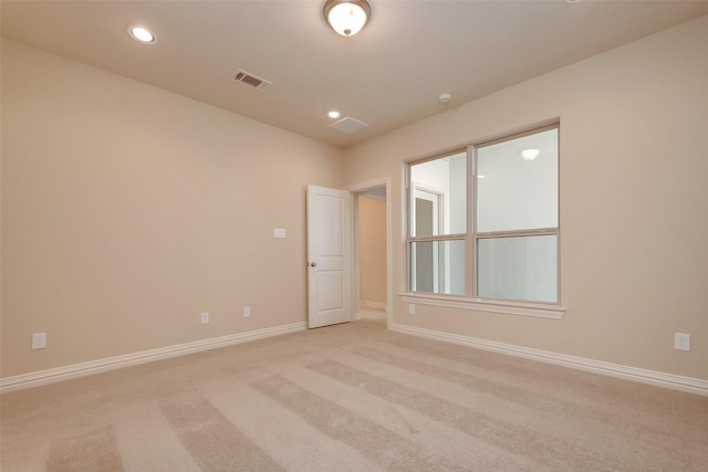 spare room featuring recessed lighting, visible vents, light colored carpet, and baseboards