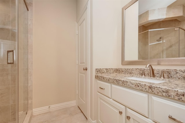 full bathroom with baseboards, vanity, a shower stall, and tile patterned flooring