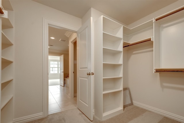 spacious closet with light tile patterned floors and light colored carpet