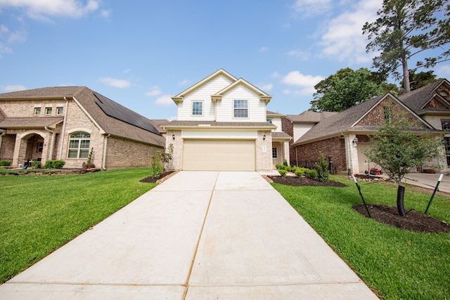 view of front of home featuring an attached garage, concrete driveway, a front lawn, solar panels, and brick siding