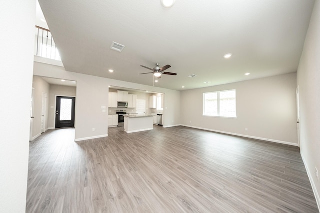 unfurnished living room featuring baseboards, a ceiling fan, and visible vents