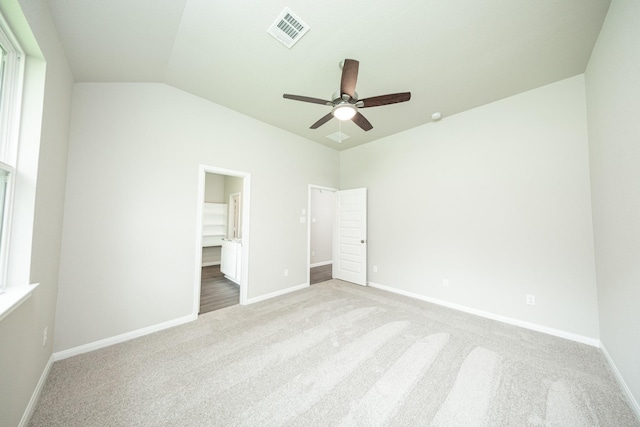 unfurnished bedroom featuring a walk in closet, carpet floors, baseboards, and visible vents
