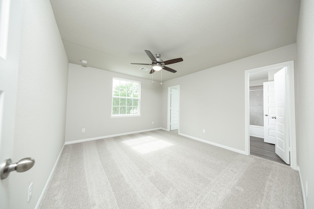 unfurnished bedroom featuring baseboards, connected bathroom, ceiling fan, and carpet floors