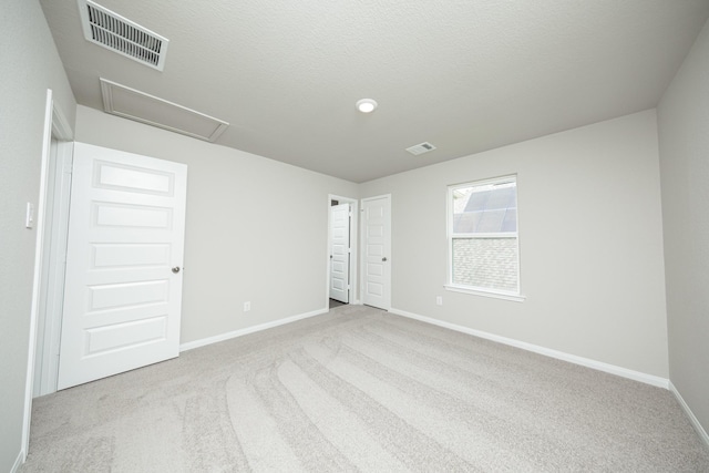 carpeted spare room featuring baseboards and visible vents