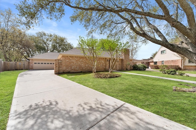 view of front of home with brick siding, a front lawn, concrete driveway, and fence