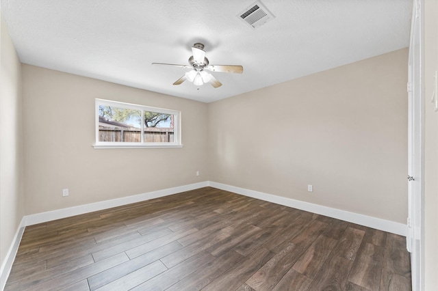 unfurnished room with visible vents, baseboards, ceiling fan, and dark wood-style flooring