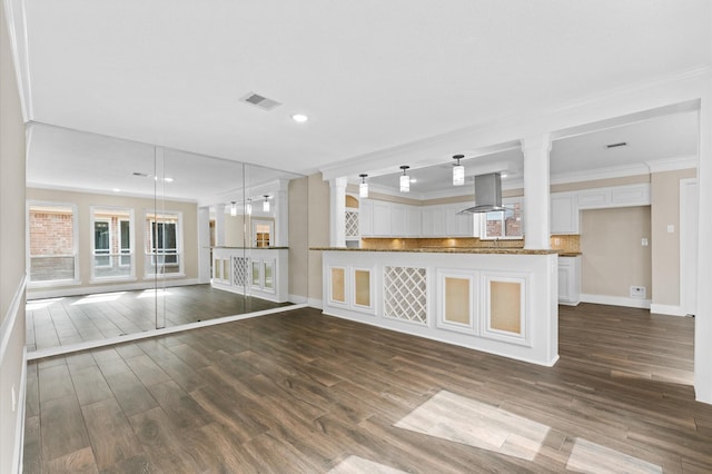 kitchen with island exhaust hood, dark wood-style flooring, white cabinets, crown molding, and backsplash