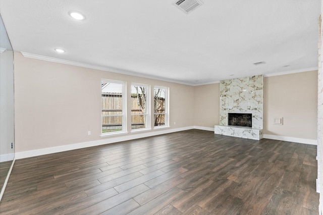 unfurnished living room with dark wood-style floors, visible vents, crown molding, and baseboards