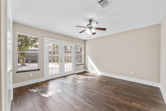 empty room with visible vents, dark wood-type flooring, baseboards, french doors, and a ceiling fan