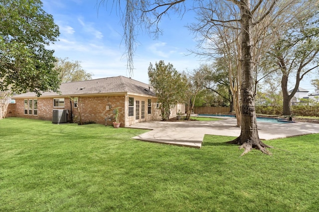view of yard featuring central AC unit, an outdoor pool, french doors, fence, and a patio