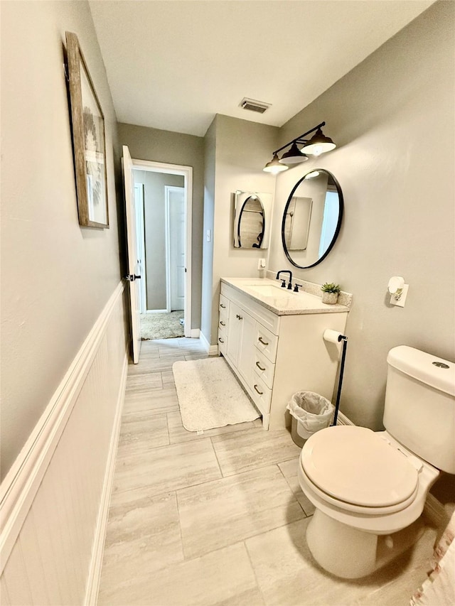 bathroom with visible vents, toilet, and vanity