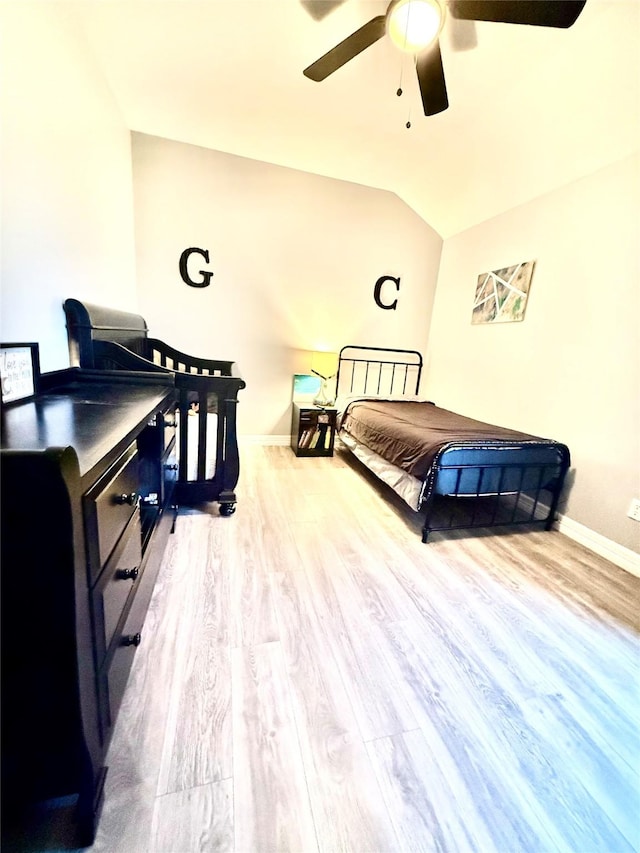 bedroom featuring lofted ceiling, baseboards, wood finished floors, and ceiling fan