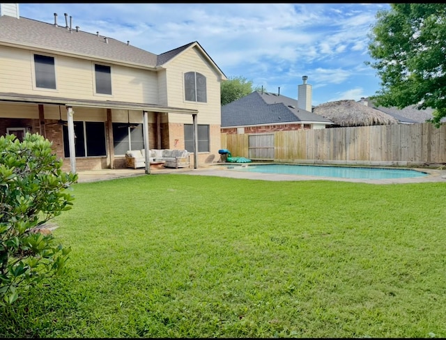 rear view of house featuring a yard, a fenced backyard, and a patio