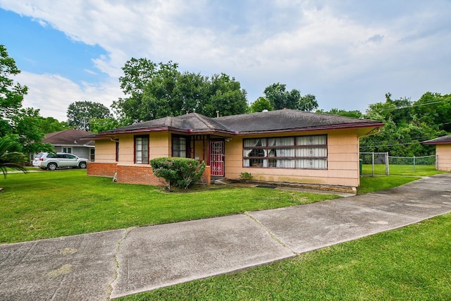 view of front of home featuring brick siding, a front lawn, and fence