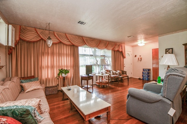 living room featuring visible vents, a textured ceiling, and wood finished floors