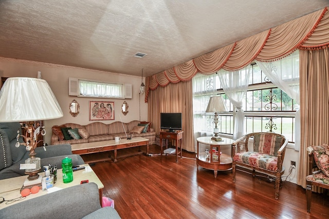 living area with visible vents, a textured ceiling, and hardwood / wood-style flooring