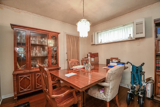 dining room featuring a notable chandelier, baseboards, and dark wood-type flooring