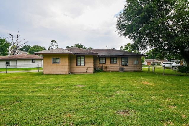 back of house with a lawn and fence