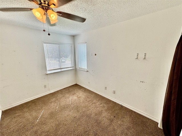 carpeted empty room with ceiling fan, a textured ceiling, baseboards, and a textured wall