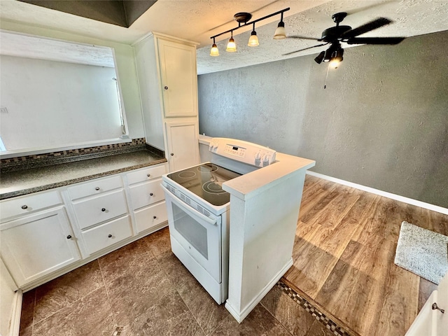 kitchen with a ceiling fan, a textured wall, dark wood-type flooring, white cabinets, and white electric range