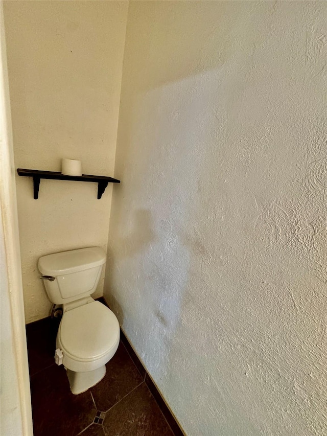 bathroom featuring tile patterned floors, baseboards, and toilet