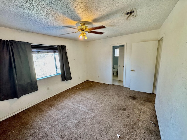 unfurnished bedroom with visible vents, carpet floors, a textured ceiling, and ensuite bathroom