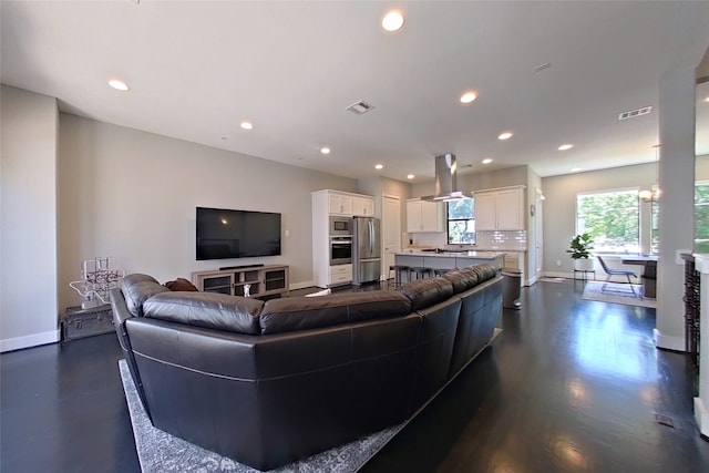 living room with recessed lighting, visible vents, and baseboards