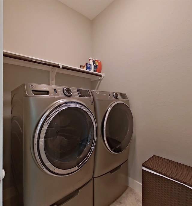 laundry room featuring washing machine and clothes dryer, laundry area, and baseboards