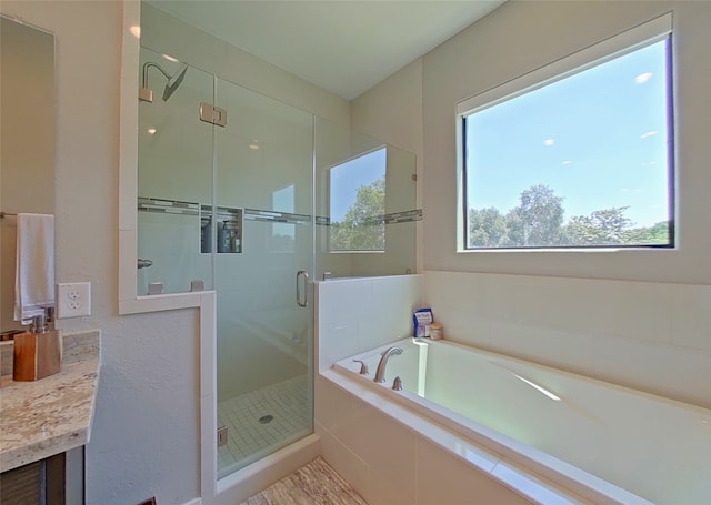 bathroom with vanity, a bath, and a stall shower