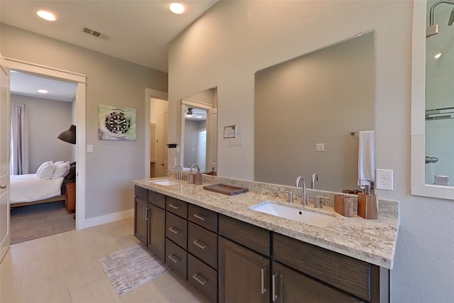 bathroom featuring double vanity, connected bathroom, visible vents, and a sink