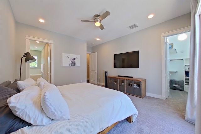 bedroom with visible vents, light carpet, ensuite bathroom, recessed lighting, and baseboards