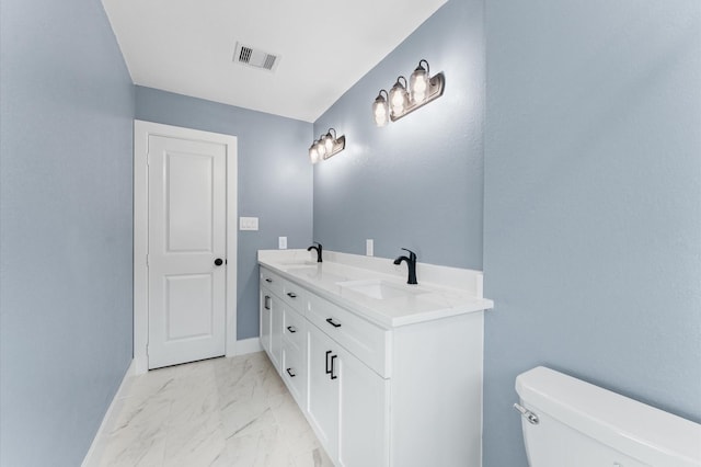 bathroom featuring toilet, visible vents, marble finish floor, and a sink