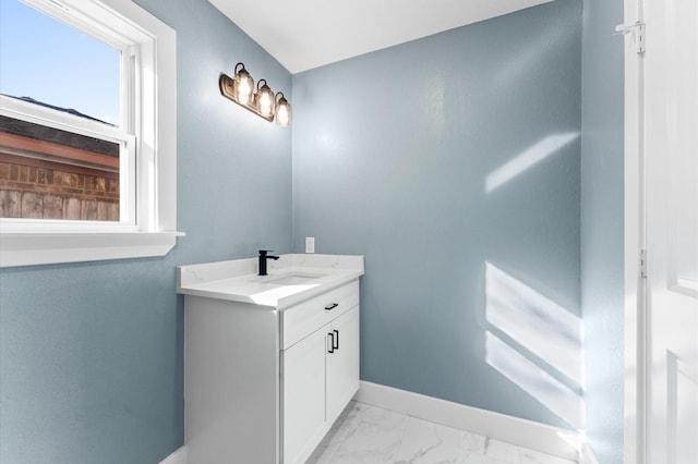 bathroom with marble finish floor, vanity, and baseboards