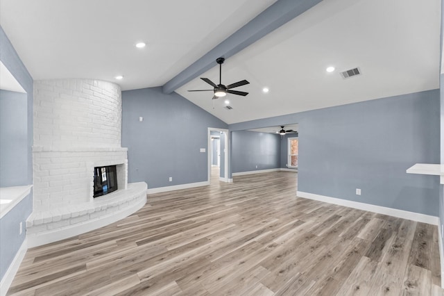 unfurnished living room featuring visible vents, light wood-style flooring, vaulted ceiling with beams, a fireplace, and ceiling fan