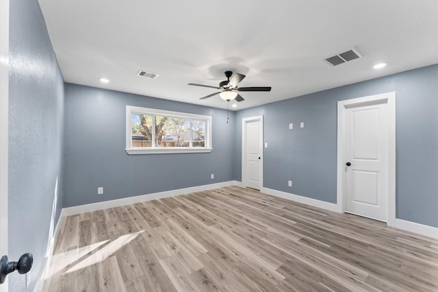 spare room with ceiling fan, visible vents, baseboards, and light wood-style flooring