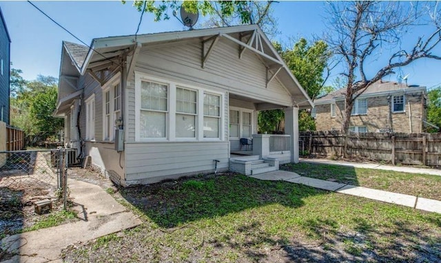 bungalow-style home with central AC unit and fence