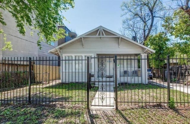 back of property featuring a fenced front yard, a chimney, and a gate