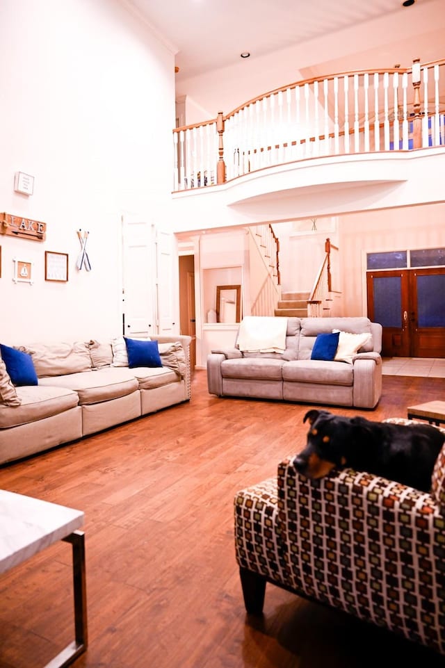 living room with a high ceiling, wood finished floors, and stairs