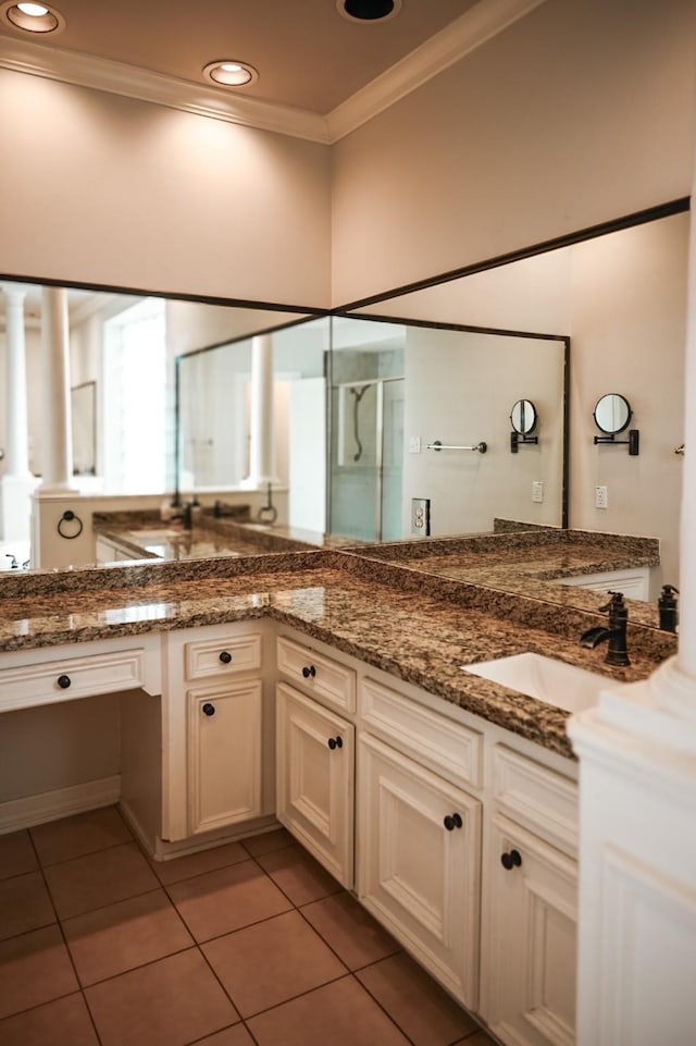 full bath featuring tile patterned flooring, ornamental molding, double vanity, a stall shower, and a sink