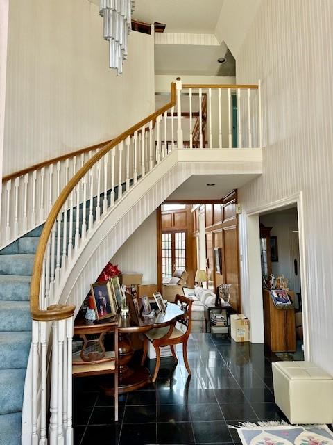 staircase featuring a towering ceiling