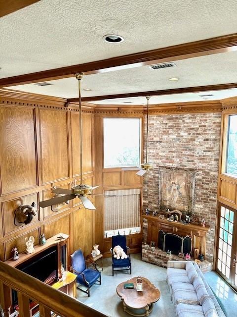 carpeted living area featuring beam ceiling, visible vents, and a textured ceiling