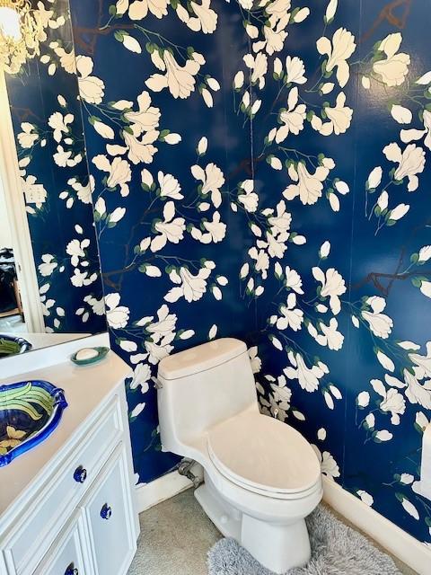 bathroom featuring baseboards, toilet, and vanity