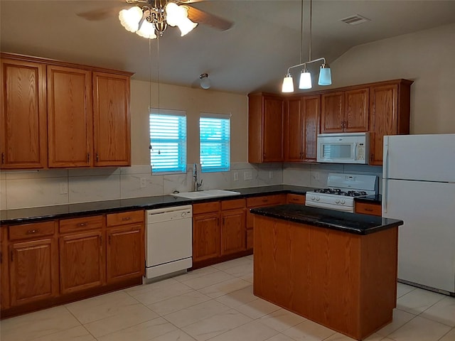 kitchen featuring white appliances, brown cabinetry, visible vents, and a sink