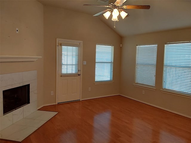 unfurnished living room featuring a tiled fireplace, wood finished floors, a ceiling fan, and vaulted ceiling