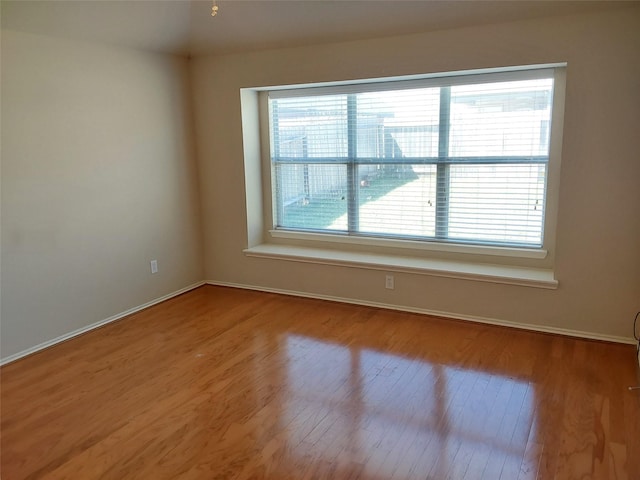 empty room with baseboards and wood finished floors