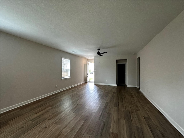 interior space featuring dark wood-style floors, ceiling fan, a textured ceiling, and baseboards