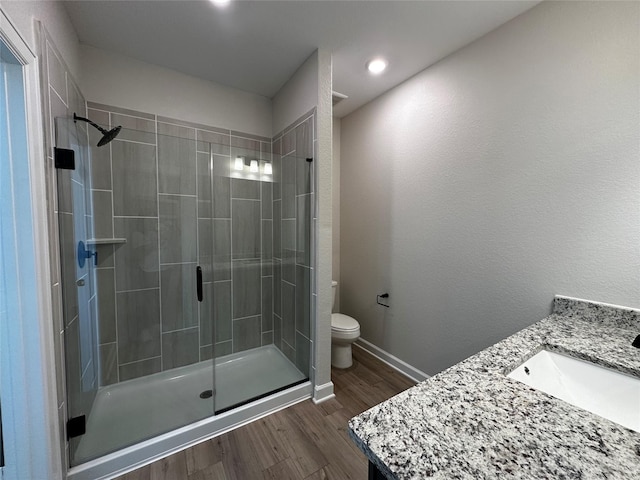 full bathroom with toilet, wood finished floors, a stall shower, and baseboards