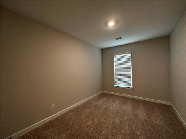 carpeted empty room with visible vents and baseboards