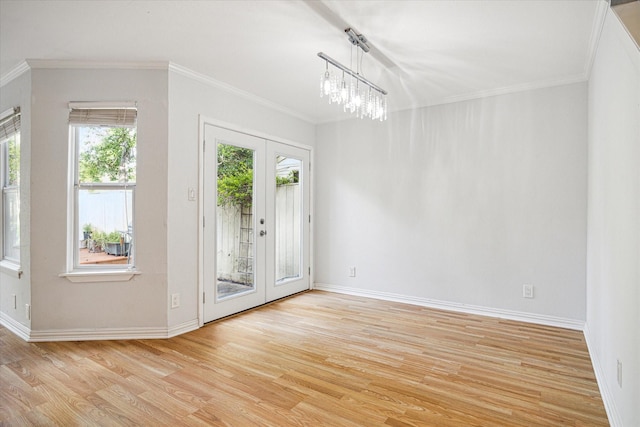 empty room with french doors, light wood-style floors, and ornamental molding